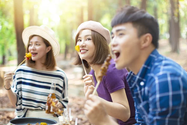 Jovens amigos comer churrasco e se divertir torcendo — Fotografia de Stock