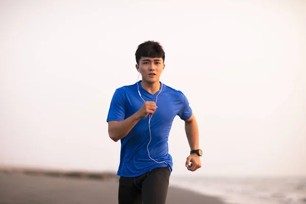 Joven hombre corriendo en la playa al atardecer —  Fotos de Stock