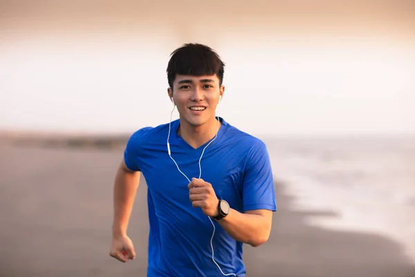 Joven hombre corriendo en la playa al atardecer —  Fotos de Stock