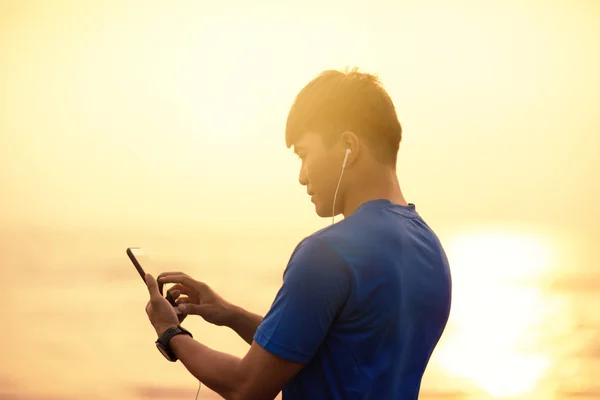 Anak muda berjalan di pantai dan memeriksa Heart Rate Monitor sm — Stok Foto