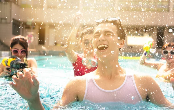 Щасливі друзі грають у басейні на літніх канікулах — стокове фото