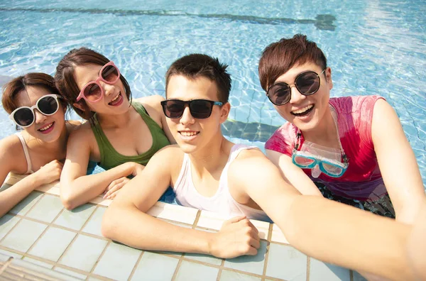 Jovens amigos felizes tomando selfie na piscina — Fotografia de Stock