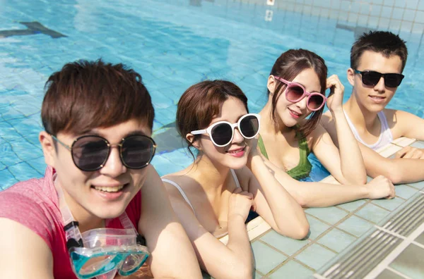 Amigos felices jugando en la piscina en las vacaciones de verano —  Fotos de Stock