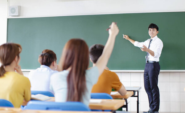 teacher with group of college students in classroom