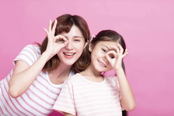 Happy mother and daughter holding fingers near eyes — Stock Photo, Image