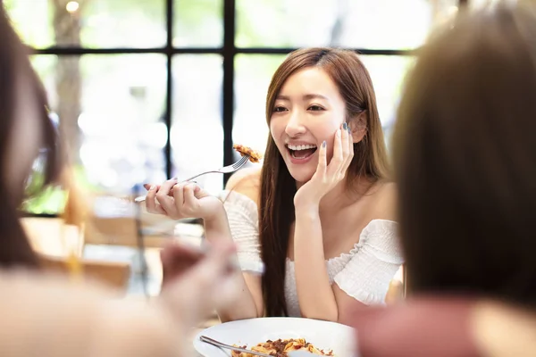 Молодая женщина с друзьями ужинает в ресторане — стоковое фото
