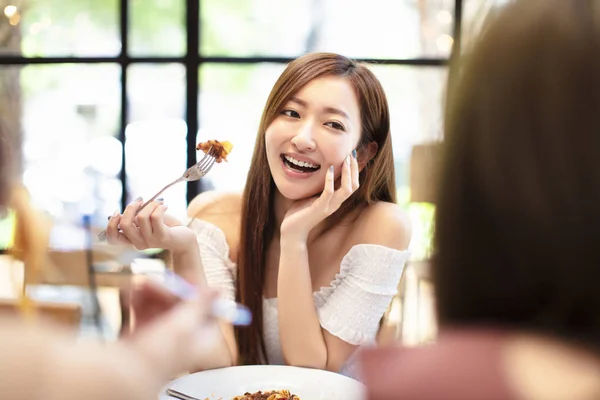 Mladá žena s přáteli na večeři v restauraci — Stock fotografie