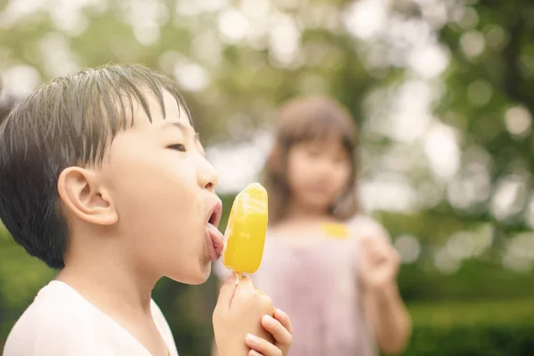 Glückliche Kinder, die im Sommer Eis am Stiel essen — Stockfoto