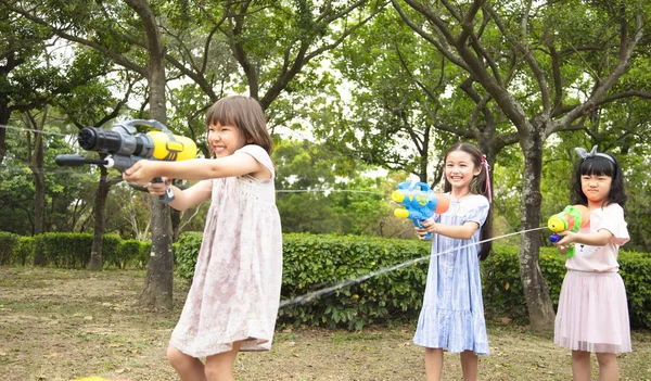 Enfants heureux jouant avec des pistolets à eau en été — Photo