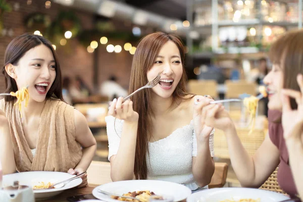Grupo de amigos felizes jantando no restaurante — Fotografia de Stock