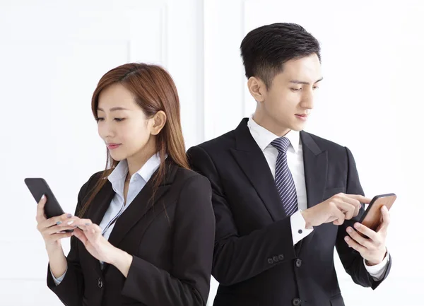 Joven mujer de negocios sonriente y hombre de negocios viendo el teléfono inteligente — Foto de Stock