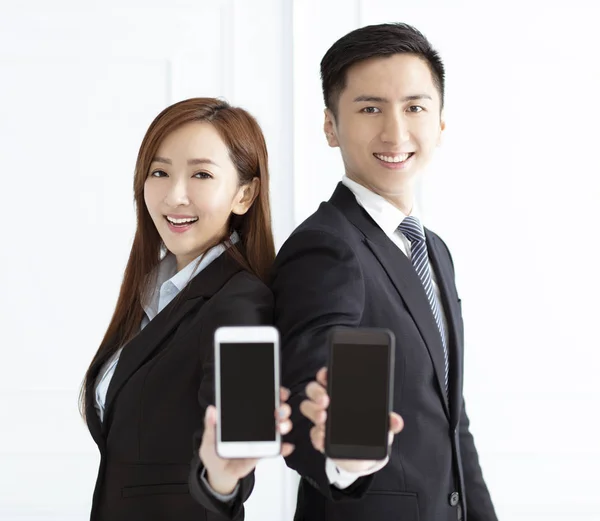 Jovem mulher de negócios sorridente e empresário mostrando telefone inteligente — Fotografia de Stock