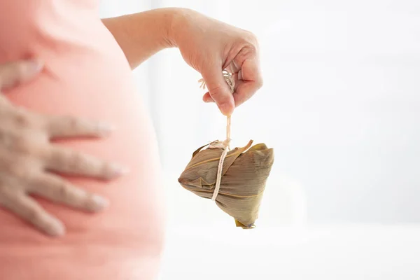 Hand holding  traditional  rice dumplings  and big belly — Stock Photo, Image