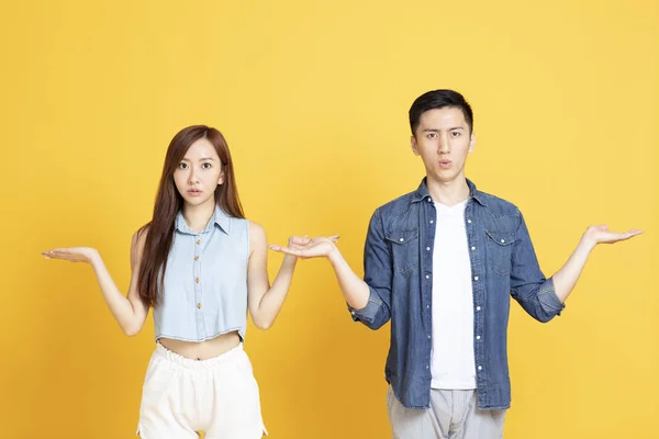 Shocked young couple showing both hands open palms — Stock Photo, Image