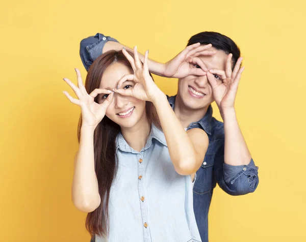 Happy  young couple showing the looking gesture — Stock Photo, Image