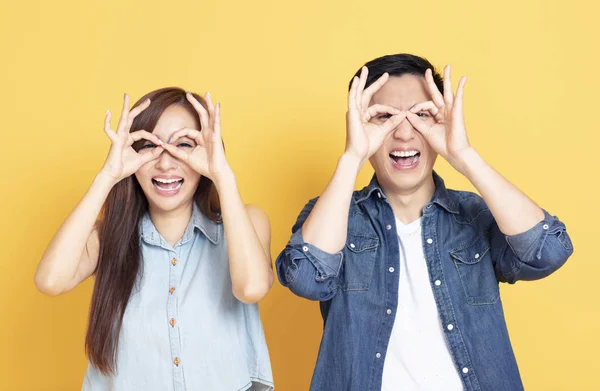 Feliz jovem casal mostrando o gesto olhando — Fotografia de Stock