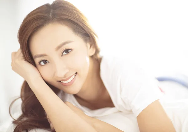 Closeup young asian smiling woman on bed — Stock Photo, Image