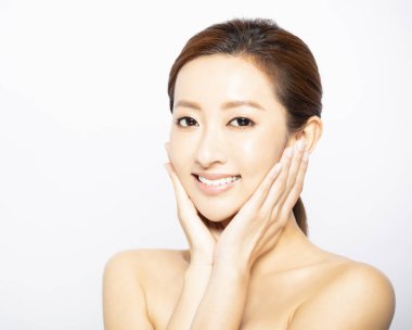 Yüzü makyajlı, cildi temiz genç bir kadın.