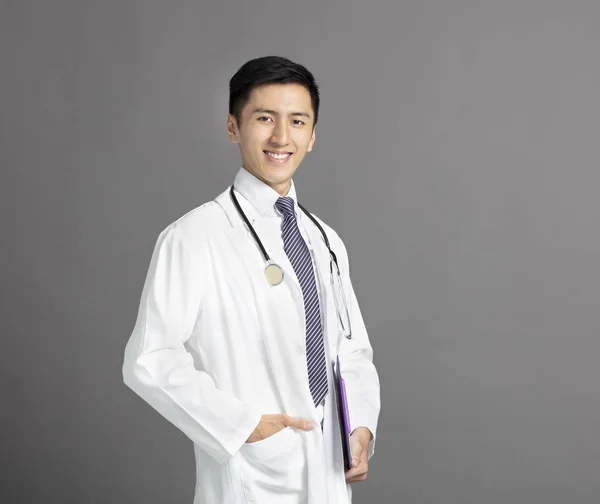 Joven guapo hombre médico aislado en gris fondo — Foto de Stock