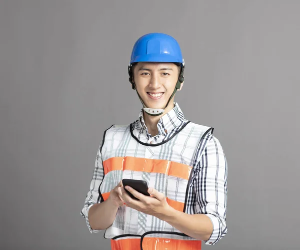 Улыбающийся азиатский молодой человек строитель — стоковое фото
