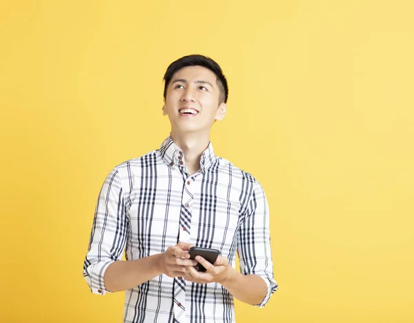 Jovem bonito usando telefone inteligente — Fotografia de Stock