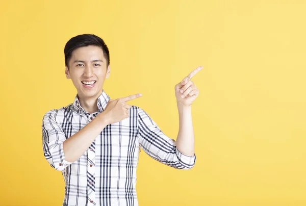 Joven guapo señalando y mostrando — Foto de Stock