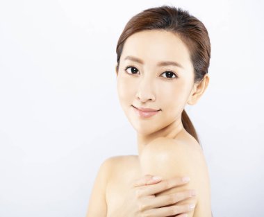 Yüzü makyajlı, cildi temiz genç bir kadın.