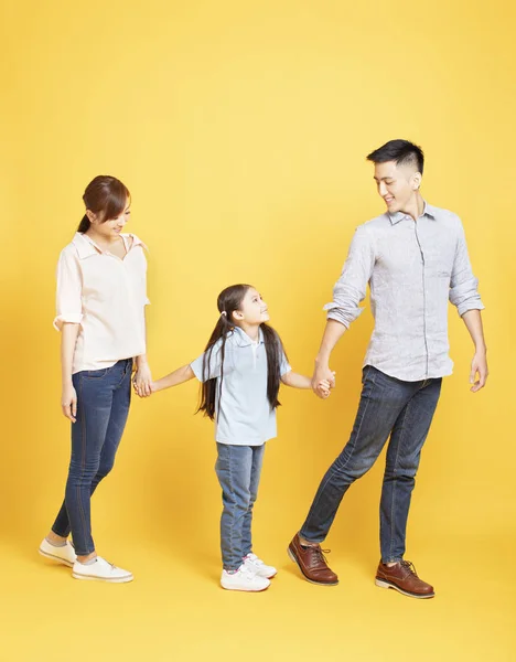 Sarı backgro üzerinde yürüyen mutlu aile tam uzunlukta portre — Stok fotoğraf