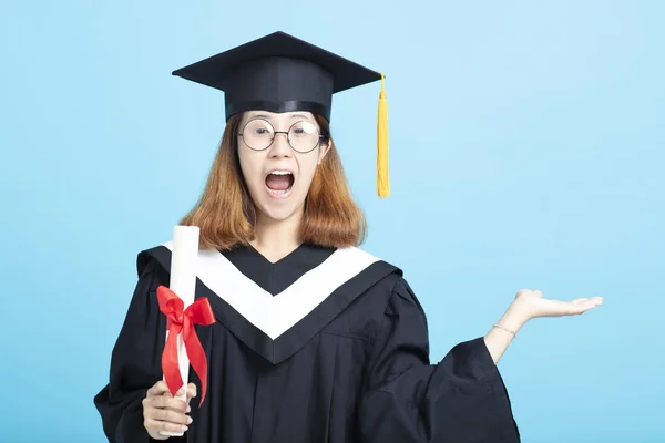 Glad och upphetsad examens flickan visar något på sidan — Stockfoto