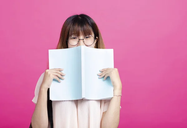 Portret van jong meisje achter een open boek — Stockfoto
