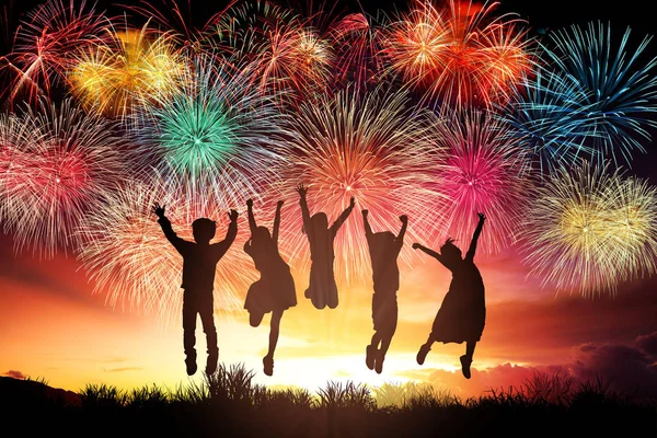 Happy children jumping and watching the fireworks — Stock Photo, Image
