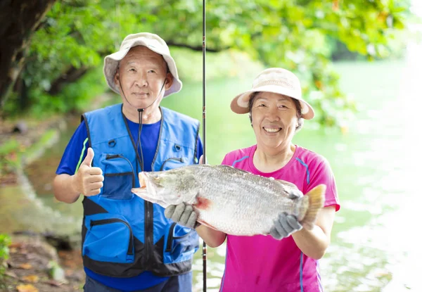 Happy Senior couple fishing at the lakeside — Stock Photo, Image