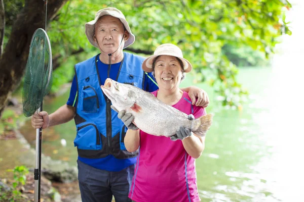 Happy Senior couple fishing at the lakeside — Stock Photo, Image