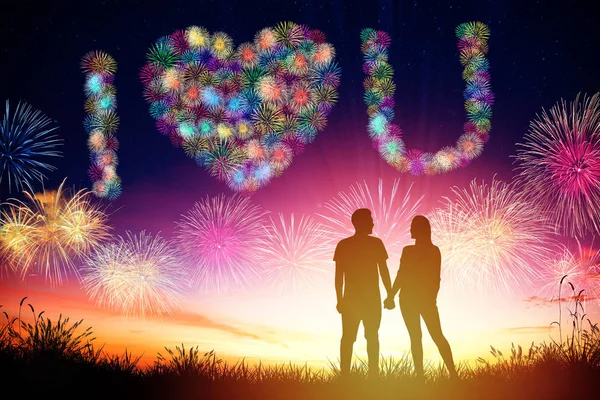 Jeune couple regarder feu d'artifice en forme de coeur sur la colline — Photo