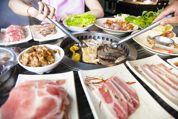 People eating barbecue beef in restaurant — Stock Photo, Image