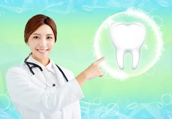 Smiling female doctor pointing health tooth icon