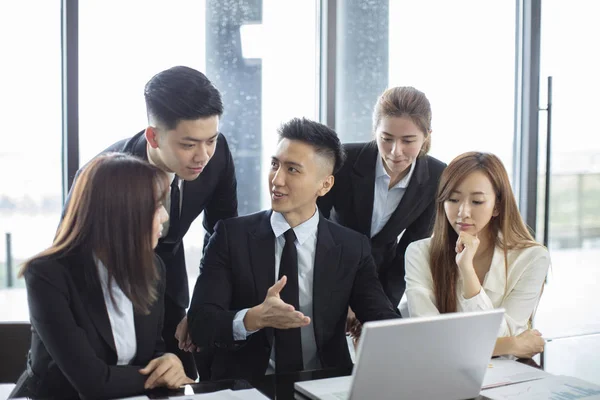 Pessoas de negócios olhando para o computador portátil e falando duri — Fotografia de Stock