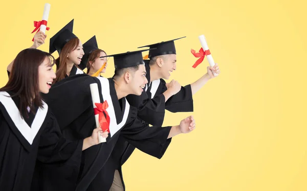 Gruppo di studenti che corre e celebra la laurea — Foto Stock