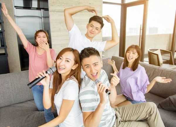 En grupp vänner som spelar karaoke hemma — Stockfoto