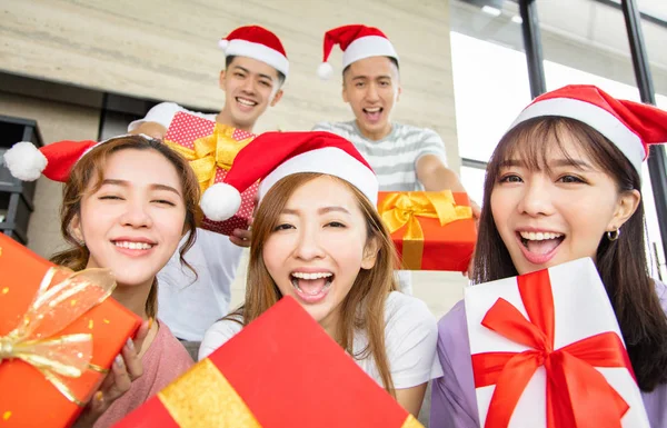 Jonge mensen met plezier en het tonen van kerstcadeau — Stockfoto