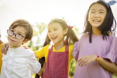 Okul çocukları gülüyor ve kucaklayan çok etnik grup