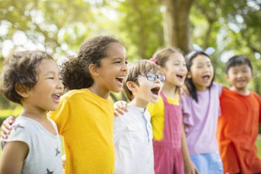 Okul çocukları gülüyor ve kucaklayan çok etnik grup