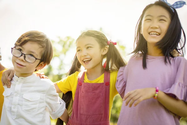 Multiethnische Gruppe von Schulkindern, die lachen und sich umarmen — Stockfoto