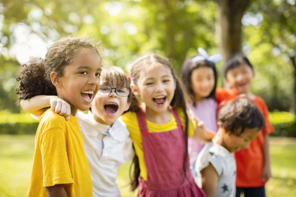 Grupo multiétnico de escolares que se ríen y abrazan — Foto de Stock