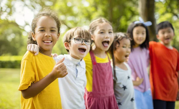 笑い、抱きしめる学校の子供たちの多民族グループ — ストック写真