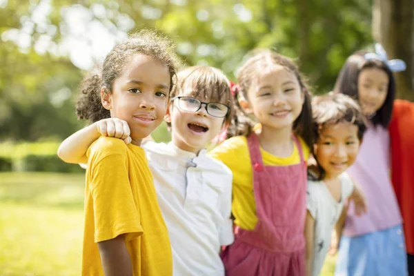 Grupo multiétnico de escolares que se ríen y abrazan — Foto de Stock