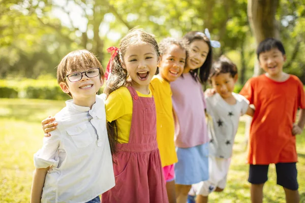 Okul çocukları gülüyor ve kucaklayan çok etnik grup