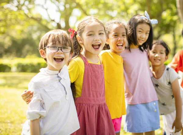 笑い、抱きしめる学校の子供たちの多民族グループ — ストック写真