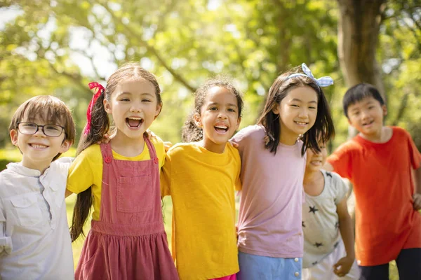 Multiethnische Gruppe von Schulkindern, die lachen und sich umarmen — Stockfoto