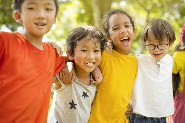 Multi-etnische groep van schoolkinderen lachen en omarmen — Stockfoto